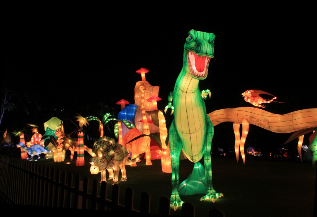 滨海湾花园内展示比人还要高大的恐龙灯笼，吸引不少游客争相合照。