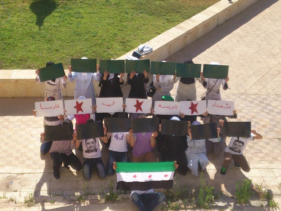 STUDENT PROTEST: This is a silent protest that took place on a Syrian university campus. The picture shows students holding placards depicting the Syrian flag. some of the protesters are wearing shirts with a picture of the latest martyr who was killed in an earlier demonstration. PHOTO: ZAHED