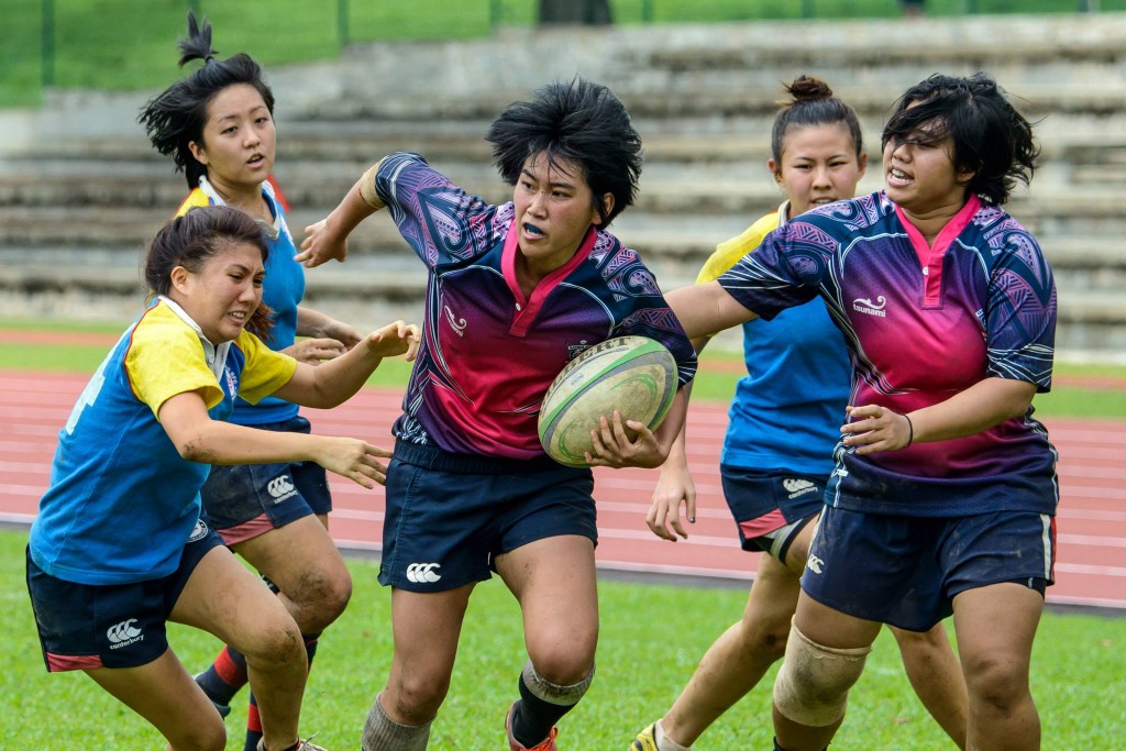 EVADING THE TACKLE: Chua sprints clear of her opponents.