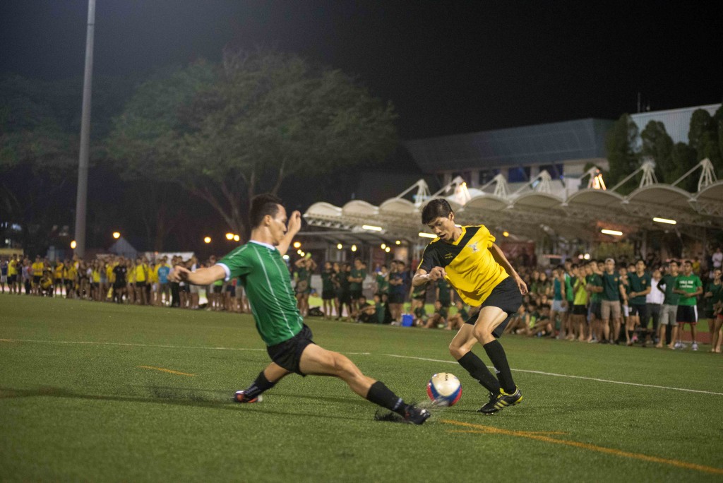 Hall 3 midfielder Hieng Pheak Kdey skips past a challenge from Hall 6's Nicholas Lim during the IHG football men's finals. PHOTO: KENJI KWOK