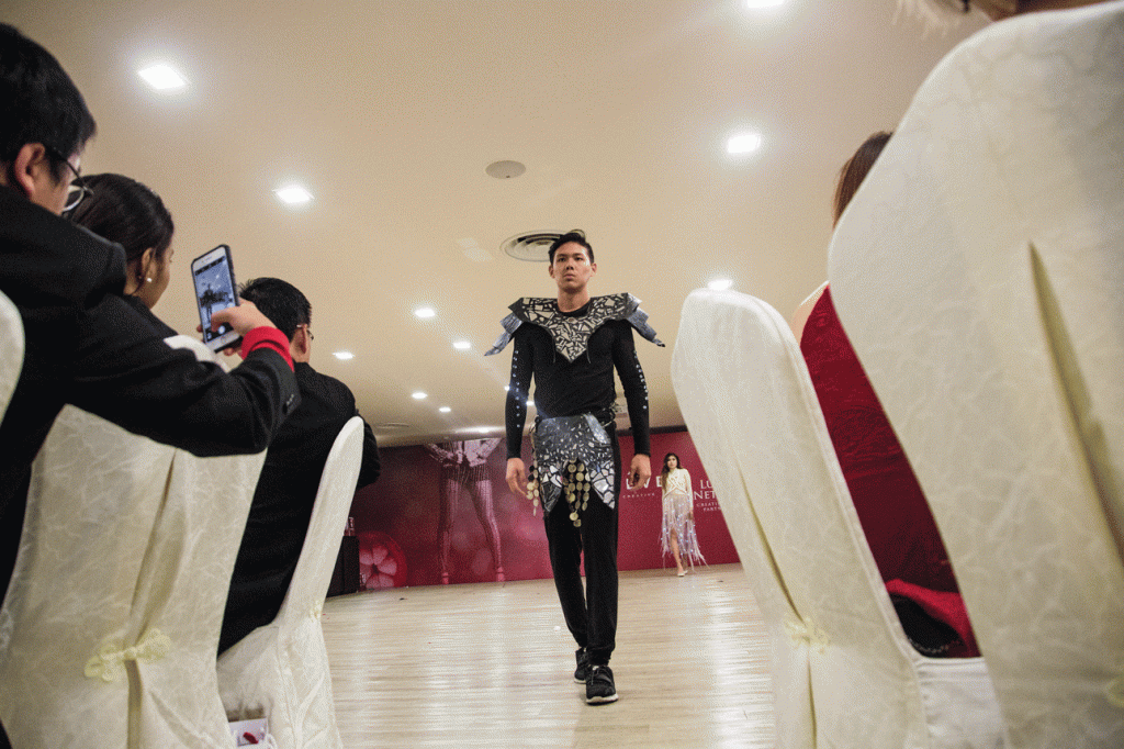ADM student Jeremy Ng models in a suit designed by Dinie Solihah Abbas. The design draws from the concept of endangered pangolins where lights represent ants and broken mirrors represent pain. 